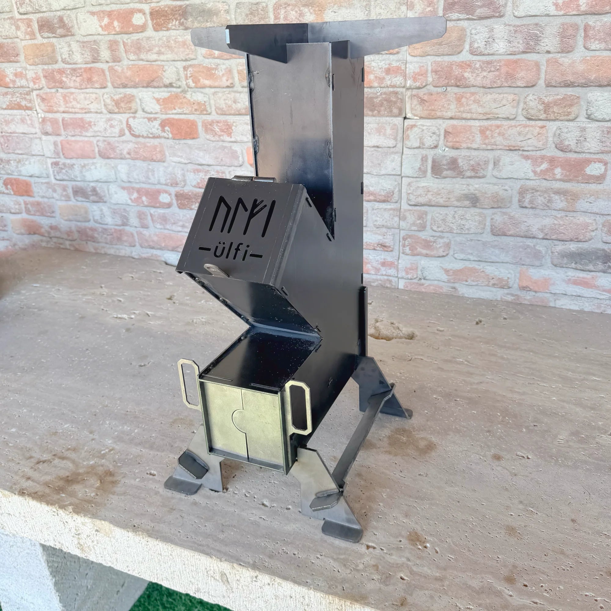 Porte logotée ÜLFI sur paumelle soudée du rocket stove MAGMA
